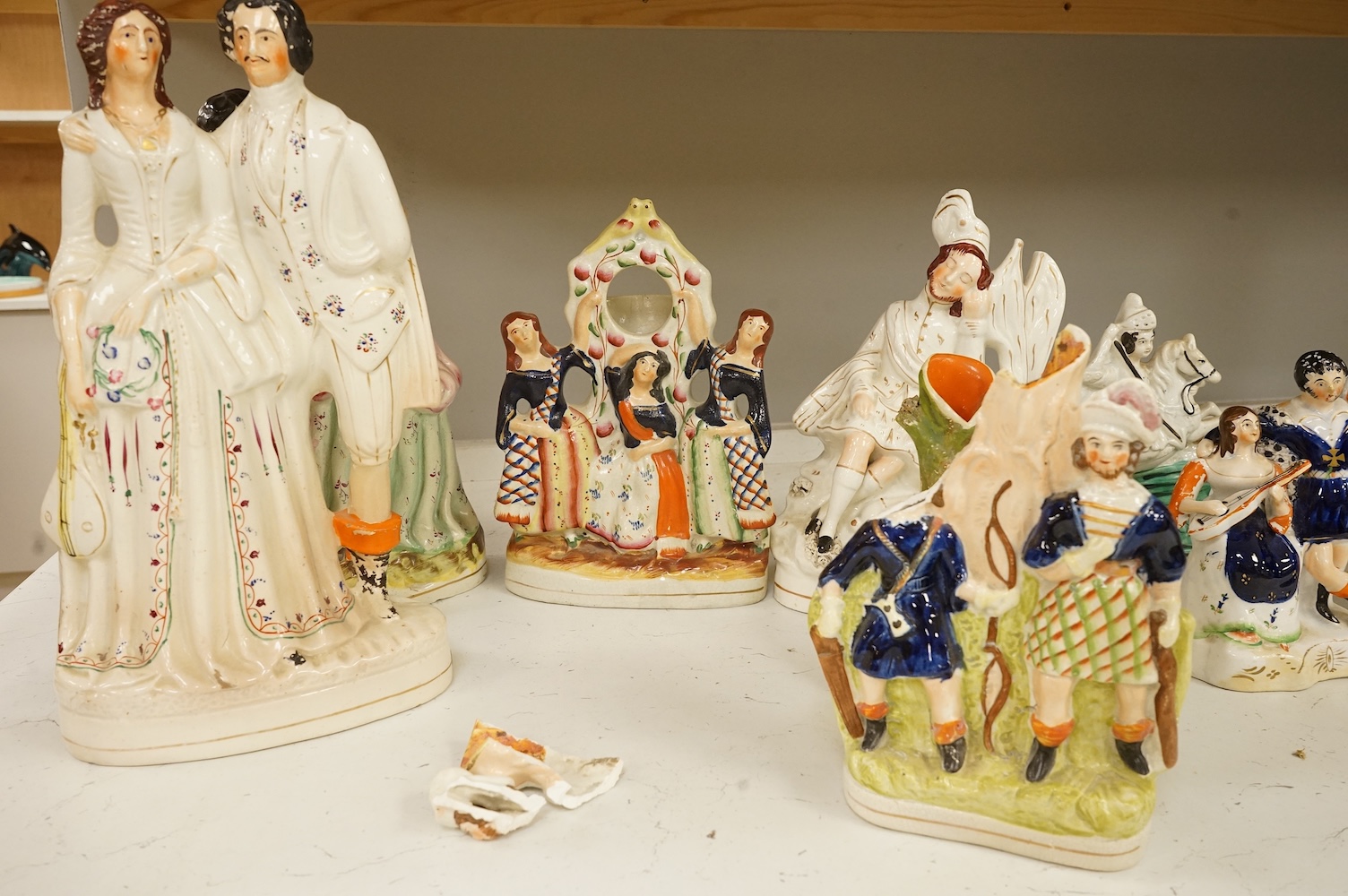 A collection of Staffordshire figures, mostly flatback to include a pocket watch holder, largest 37cm high